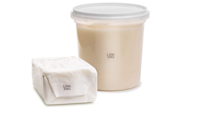 Butter in plastic wrap and cream cheese plastic tub marked with black continuous inkjet